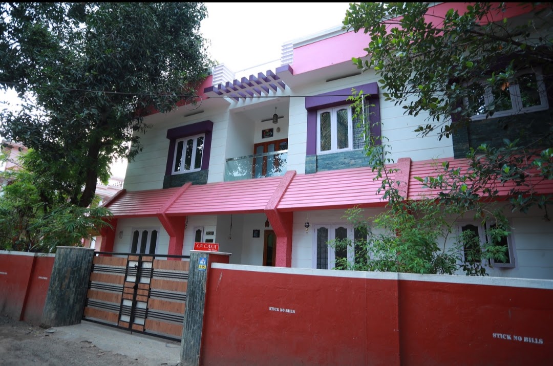 Lacasa Homestay exterior with red boundary wall and gate
